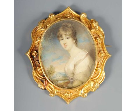 A REGENCY 18CT GOLD FRAMED MINIATURE PORTRAIT ON IVORY depicting a young woman in classical dress in glazed rococo style fram