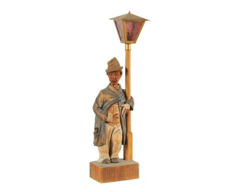 A 1930’S SUNLEY MUSICAL PRODUCTS GERMAN CARVED POLYCHROME AUTOMATON FIGURE TABLE LAMP the whistling standing figure by a lamp