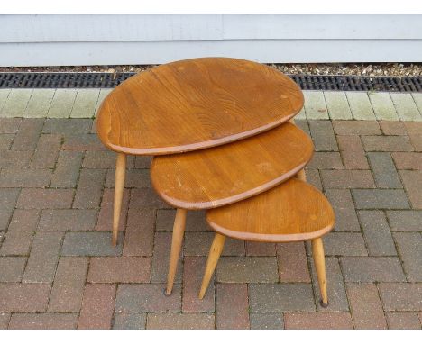 An Ercol light Elm finish nest of three pebble tables. Largest 65cm x 44cm x 40cm high