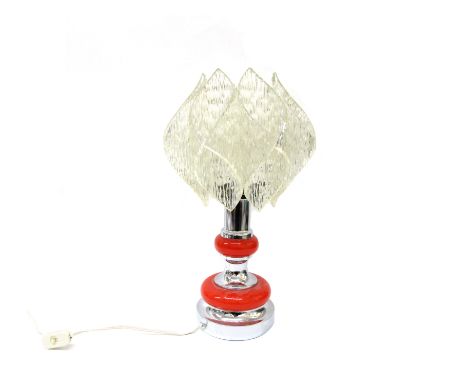 A chromed metal and orange table lamp base with a folded and textured clear perspex shade. Overall 49cm high