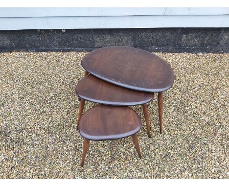 An Ercol nest of three pebble tables in the dark oak finish 64cm X 44cm x 40cm high