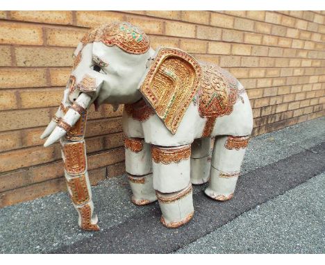A Burmese ornately decorated articulated wooden elephant, from the Mandalay Puppet Theatre, approximate height 70cm.