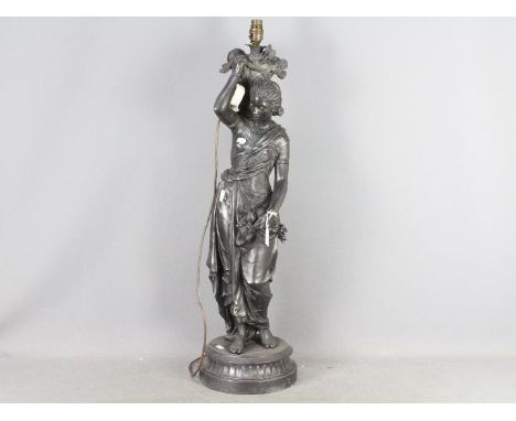 A large cast metal lamp in the form of a lady carrying baskets of fruit, approximately 80 cm (h).