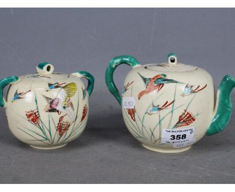 A Japanese teapot and sugar bowl with cover, hand painted decoration of birds in flight, signed. [2]