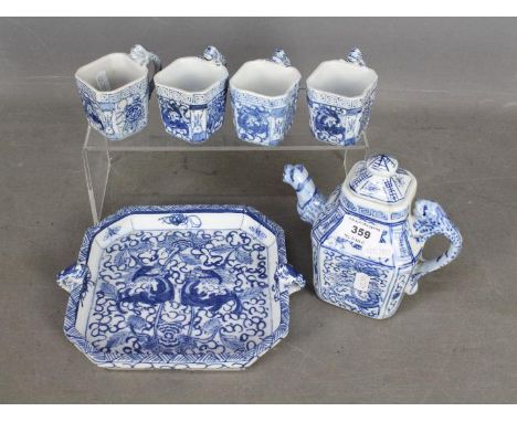 A Chinese blue and white tea set comprising teapot, four cups and tray, with applied chilong handles. [6]