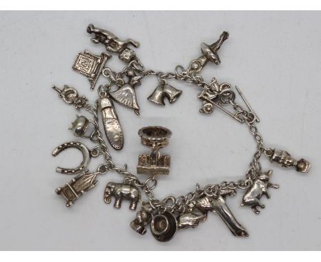 A white metal (presumed silver but unmarked) charm bracelet and charms, approximately 52.9 grams all in.