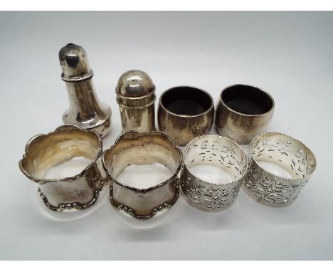 A collection of hallmarked silver items comprising six napkin rings (two are silver mounted to a  plastic core) and two cruet