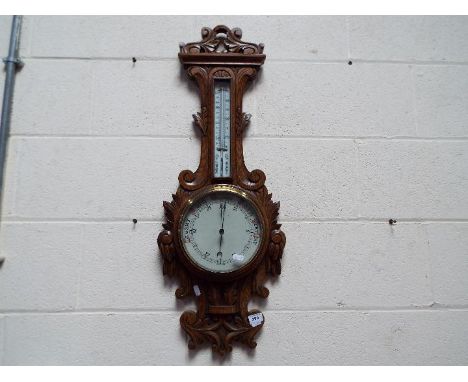 A highly carved banjo barometer / thermometer.