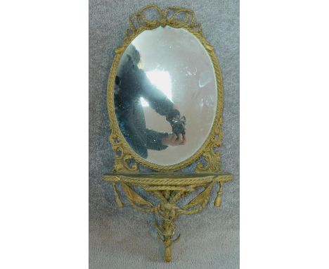 A late 19th century gesso framed wall mirror with shaped shelf and ribbon and swag decoration. 72x36cm 