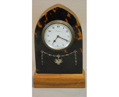 A tortoiseshell cased lancet shaped mantel clock with white metal swag inlay. Swiss made movement. H.13 W.8cm 