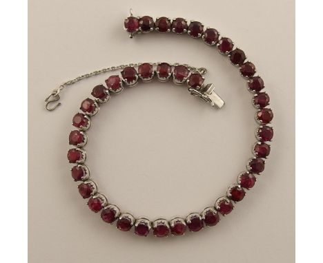 A ruby line bracelet the thirty nine facet cut rubies are claw set in a classic line bracelet configuration to four clawed ga