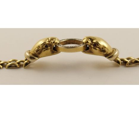 An 18ct gold leopard head bracelet the yellow gold leopards are clasping a diamond set yellow gold ring between their teeth, 