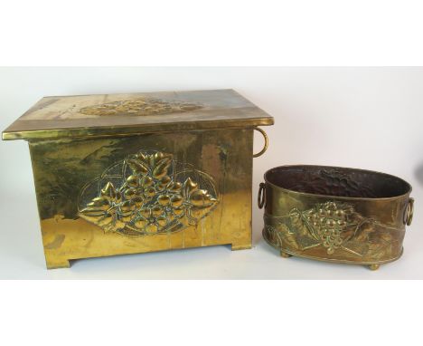 A Glasgow School Arts and Crafts brass repousse work log box the oblong box decorated with panels of stylised leaves and flow