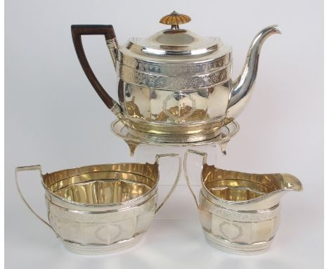 A three piece silver tea service with teapot stand by Andrew Spence, Edinburgh 1805, of oval shape, the faceted body with eng