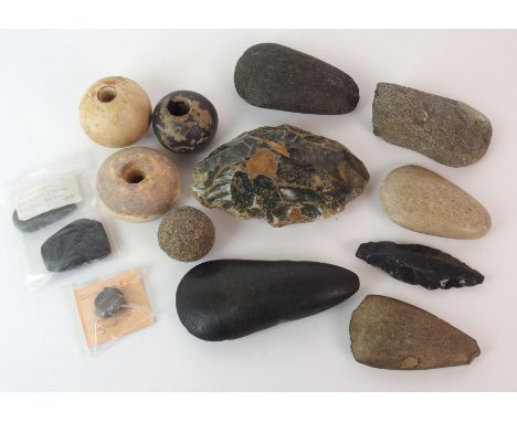 A group of Neolithic stone axe heads flint scraper, Ichthyosaur vertebrae, three pierced circular stone weights and a stone c