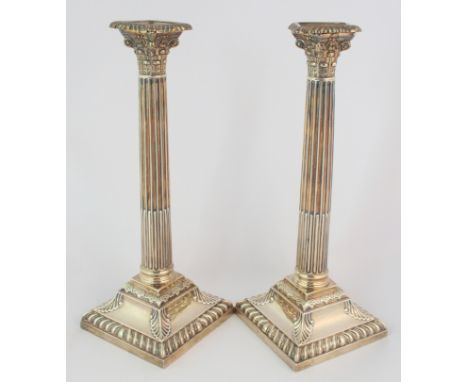 A pair of silver candlesticks by Henry Wilkinson & Co., rubbed London hallmarks, of Corinthian form, with removable drip pans