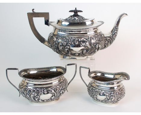 A three piece silver tea service by Williams (Birmingham) Limited, Birmingham 1906, of oval bombe shape with foliate embossin