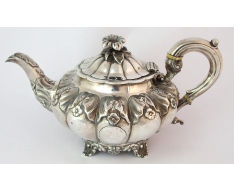 A 19th Century silver teapot by William Hewitt, London 1836, of melon shape with foliate and flowerhead embossing on four scr