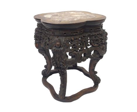 A Chinese carved hardwood pedestal with inset quatrefoil marble top above pierced foliate frieze divided by grotesque masks a