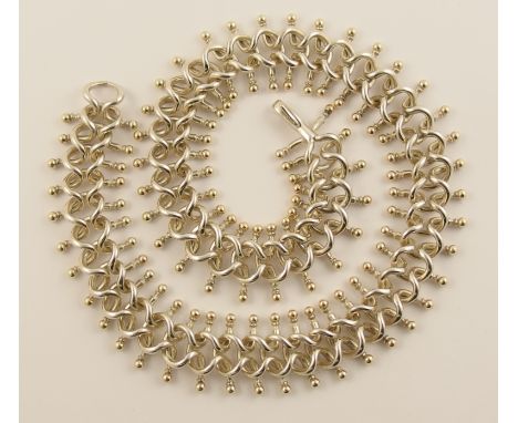 A Decorative chain made by Brett Payne the highly flexible chain is made of repeat pattern units intertwined with gold ball t