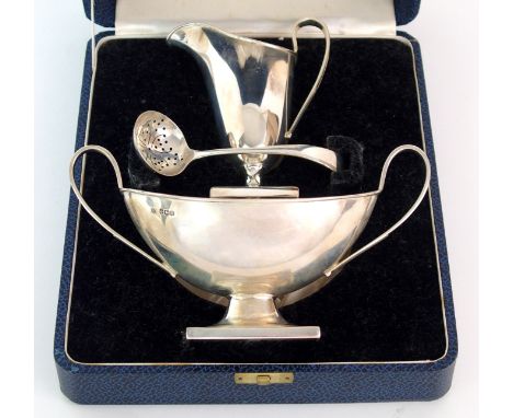 A cased silver cream and sugar by Emile Viner, Sheffield 1937, the boat shaped sugar bowl with twin looping handles on square