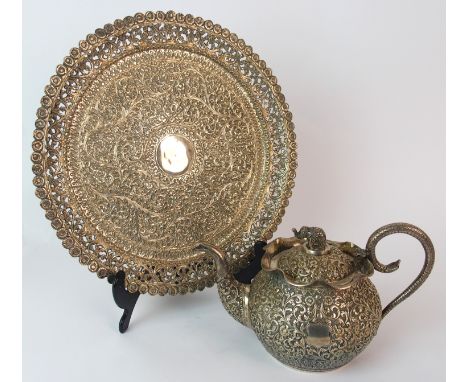 An Indian silver teapot and cover chased allover with foliage divided by a shield, elephant finial, stamped T85, 19cm wide an