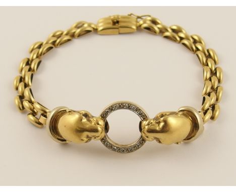 An 18ct gold leopard head bracelet the yellow gold leopards are clasping a diamond set white gold ring between their teeth, t