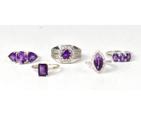 Five silver and amethyst rings, to include a three-stone claw set oval amethyst ring, size S, a ring with a cut marquise-shap