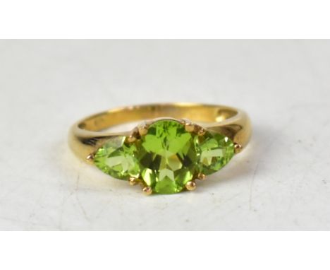 A 9ct gold three-stone peridot ring, the central marquise claw set stone flanked by claw set stone, size P, approx 2.4g. COND