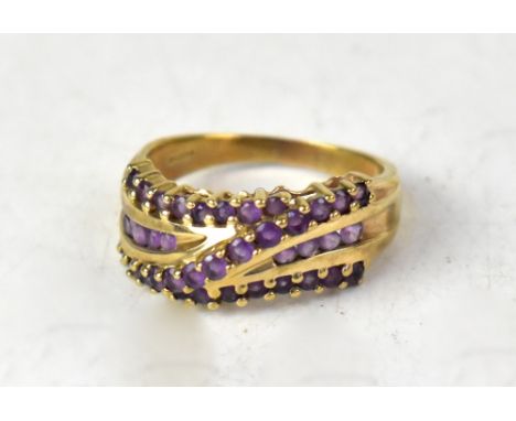 A 9ct yellow gold fancy ring set with two horizontal and one diagonal line of amethyst claw set stones, size Q, approx 4.2g.