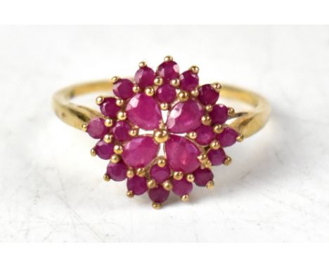 A 9ct gold ruby cluster ring, comprising approximately twenty-four various sized pear-shaped and round red rubies, on a 9ct y