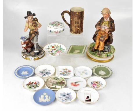 Two Capodimonte figures comprising an elderly tailor seated in countryside with workbag on his knee, height 33.5cm, and a tra