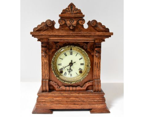 ANSONIA CLOCK CO, NEW YORK; an oak cased mantel clock with architectural pediment, the enamelled dial set with Roman numerals