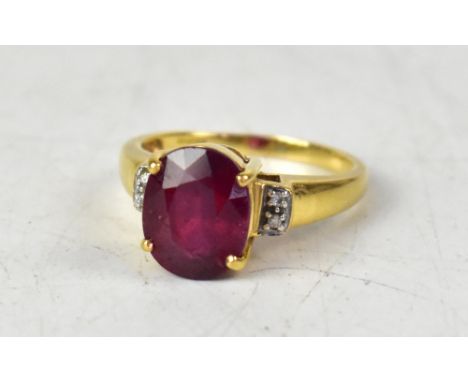 An 18ct ruby and diamond ring, the round cut Majestic stone with tiny chips to each shoulder, size Q, approx 5.9g.