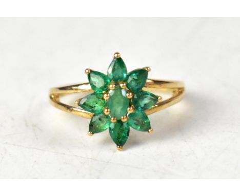 A 9ct yellow gold ring set with Terezinha emerald flowerhead with split shoulders, on a 9ct yellow gold shank. size O, approx