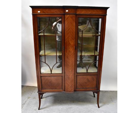 An Edwardian inlaid mahogany display cabinet with pair of astragal glazed doors flanking a central geometrically inlaid panel