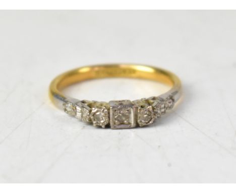 An 18ct gold Art Deco style ring with a central small claw set diamond in a square mount, flanked by two small bezel set diam