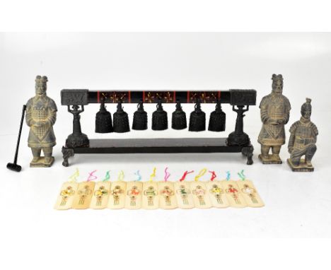 A reproduction Chinese stand bearing cast metal prayer bells, together with four reproduction terracotta army figures and a s