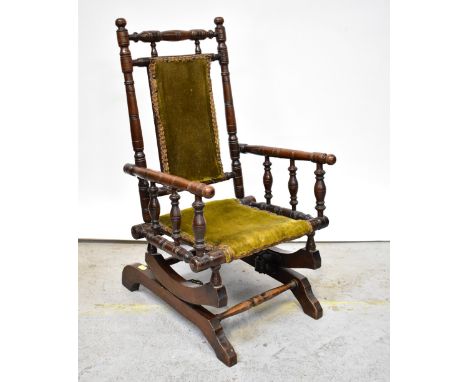 A child's late 19th/early 20th century American-style rocking chair with bobbin turned frame and upholstered back and seat.