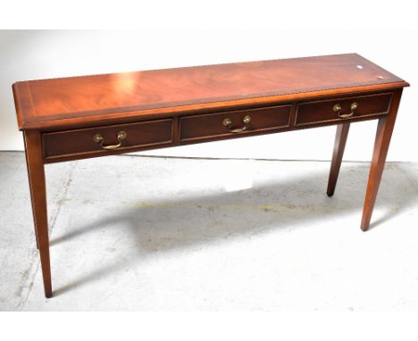 A reproduction mahogany line inlaid and crossbanded three-drawer side table, raised on square tapering supports, 69 x 138 x 3