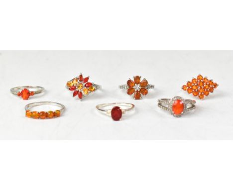 Seven orange fire opal and topaz sterling silver rings, comprising an orange Ethiopian oval five-stone ring with platinum ove