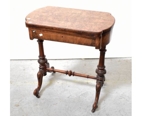 A Victorian walnut games table, the revolving shaped and inlaid top enclosing an inlaid chequerboard to one side and backgamm