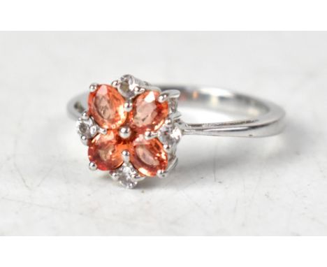 A 9ct white gold flowerhead ring, set with orange and white coloured sapphires, on a white gold shank, size N, approx 2.8g.