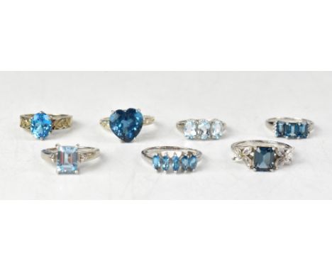 Seven topaz and sterling silver rings, comprising a three-stone ring with three claw set octagonal London blue topaz stones, 