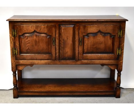 TAYLOR &amp; CO; a 20th century good oak reproduction small open backed dresser, with shaped pelmet over four shelves, over f