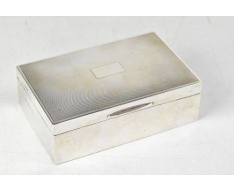 A George V hallmarked silver cigarette box with engine turned lid and blank rectangular cartouche, wooden split interior with