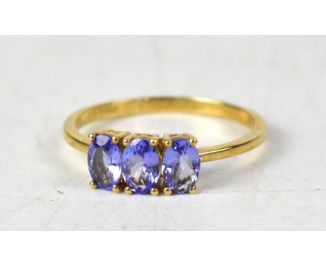 A 9ct yellow gold ring with three claw set oval tanzanite stones, size S, approx 2.1g.