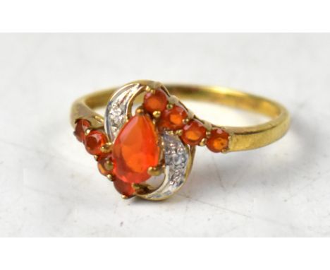 A 9ct yellow gold ring, set with central pear-shaped fire opal, with a row of four fire opals top and bottom and white topaz 