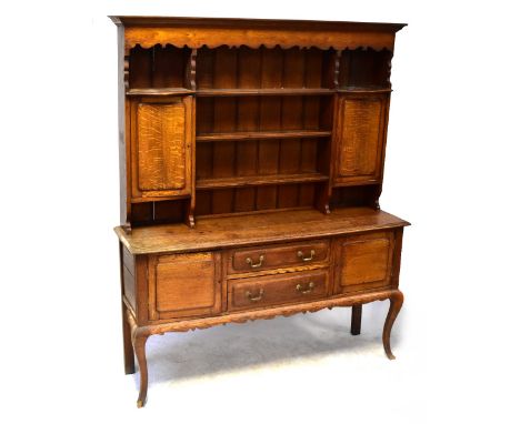 A Georgian-style oak dresser, the boarded plate rack with three shelves flanked by a pair of panelled doors, above a base of 