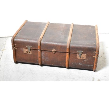 An early 20th century wooden bound canvas covered travelling trunk with metal fittings, 34 x 92 x 56cm.